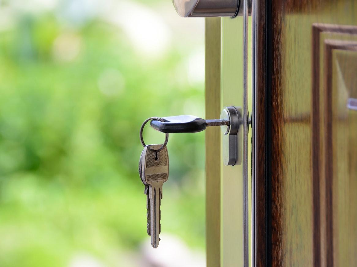 A set of keys in the lock of an open door