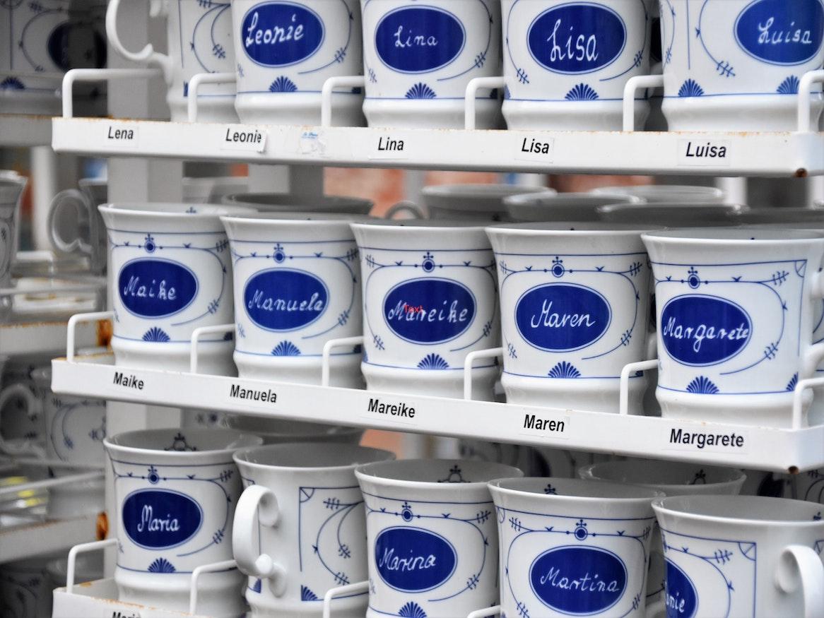 A shelf full of mugs personalised with names