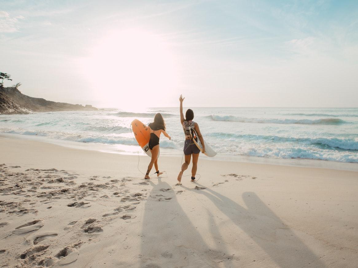 Two people holding a surfboard at the beach