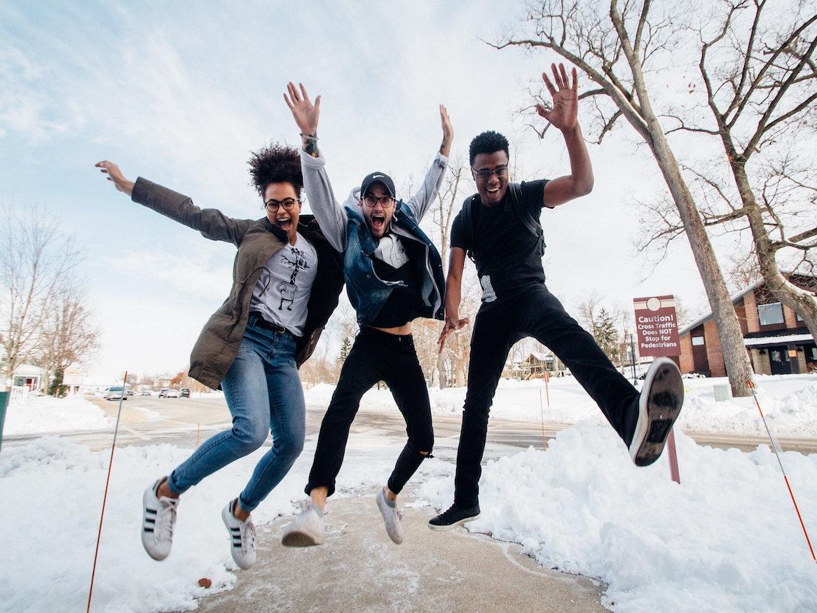 A group of friends jumping in the snow 