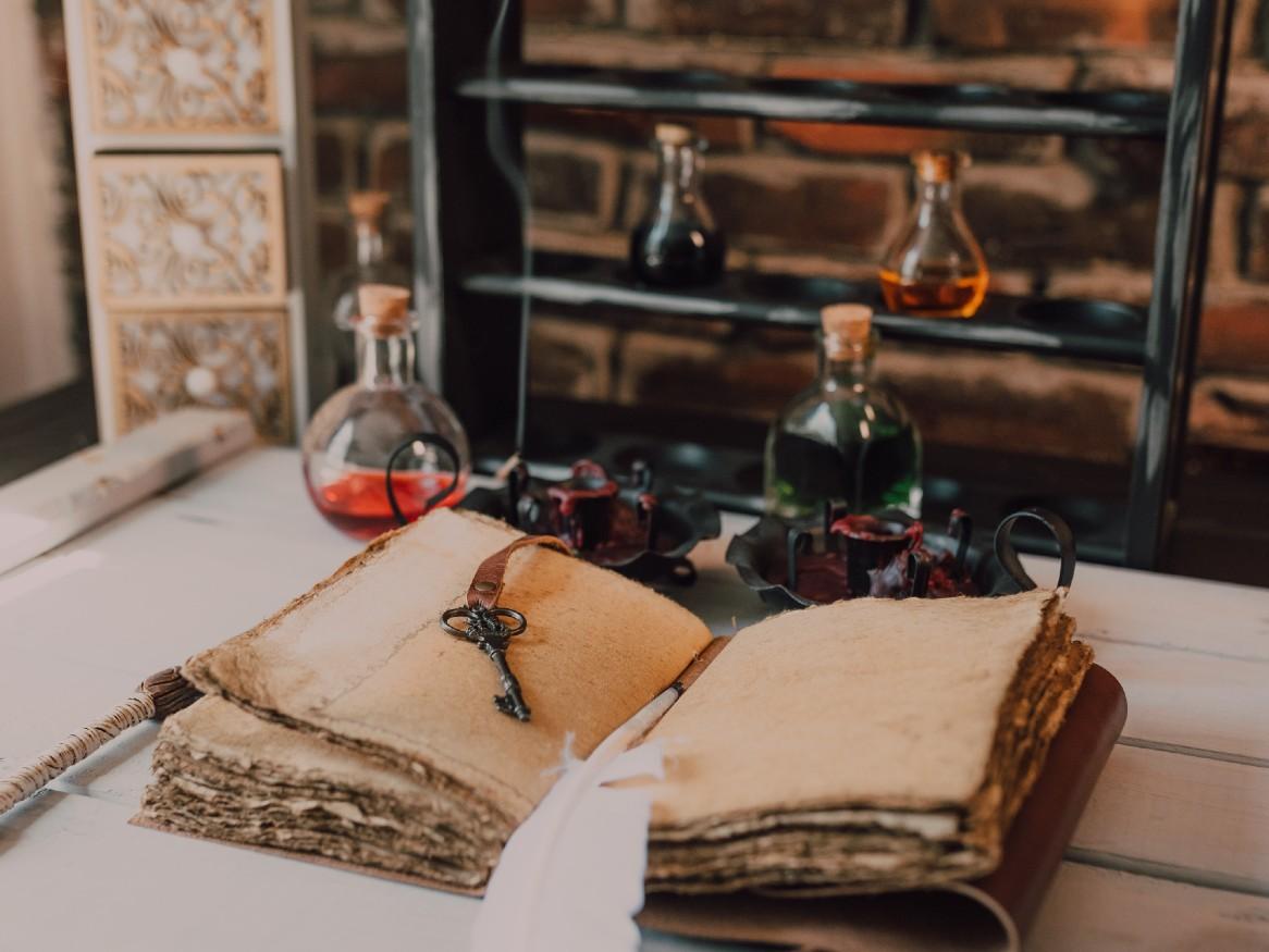 A magical book, with potions, a key, and an owl's feather