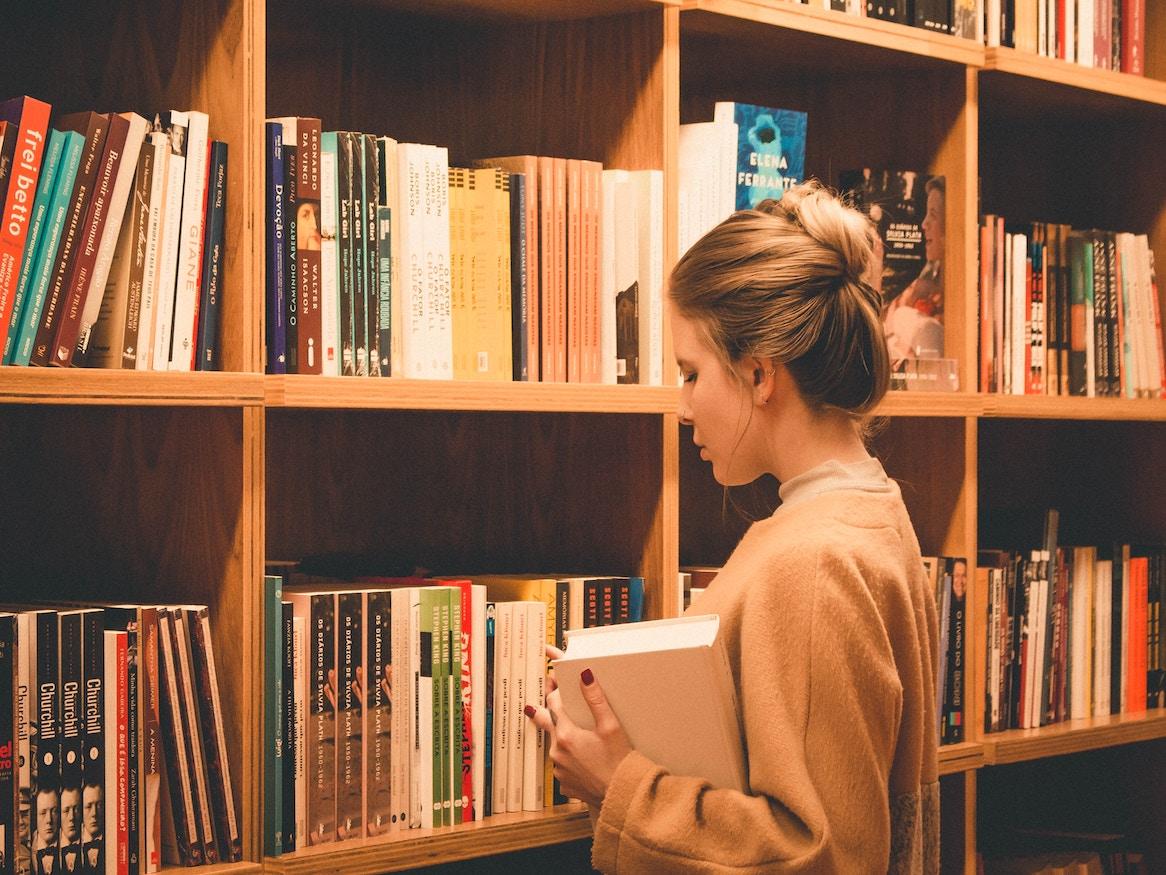 A woman browsing the library shelves.