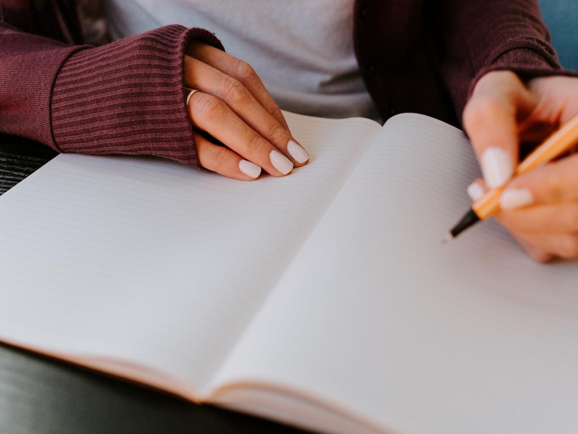 A person writing in a notebook.