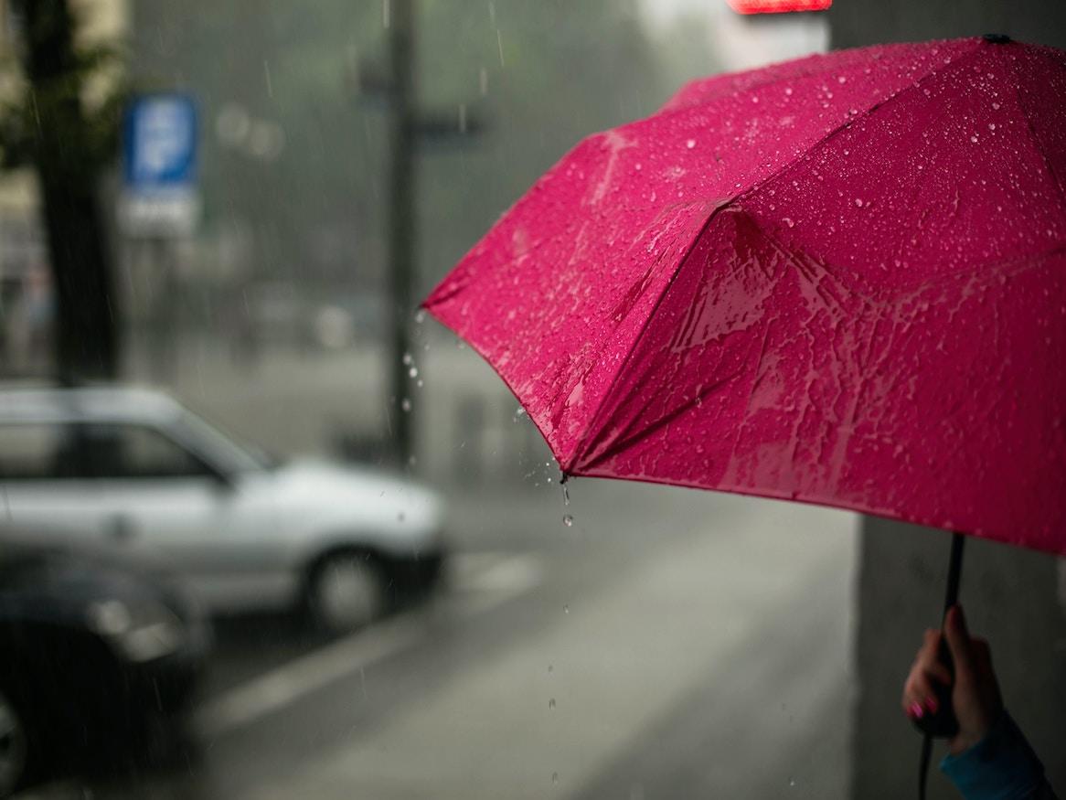 A person holding an umbrella in the rain.