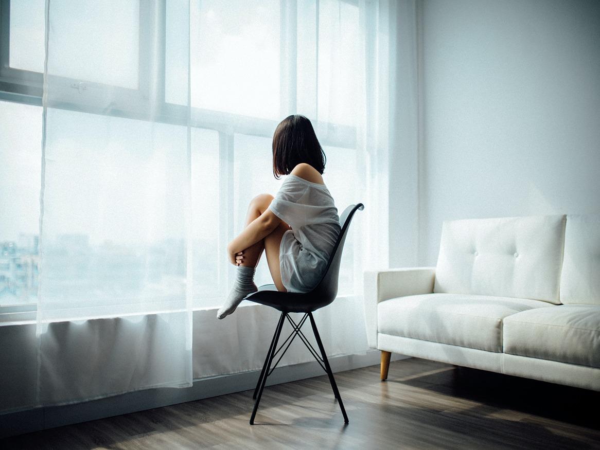 Woman relaxing on chair while looking out window