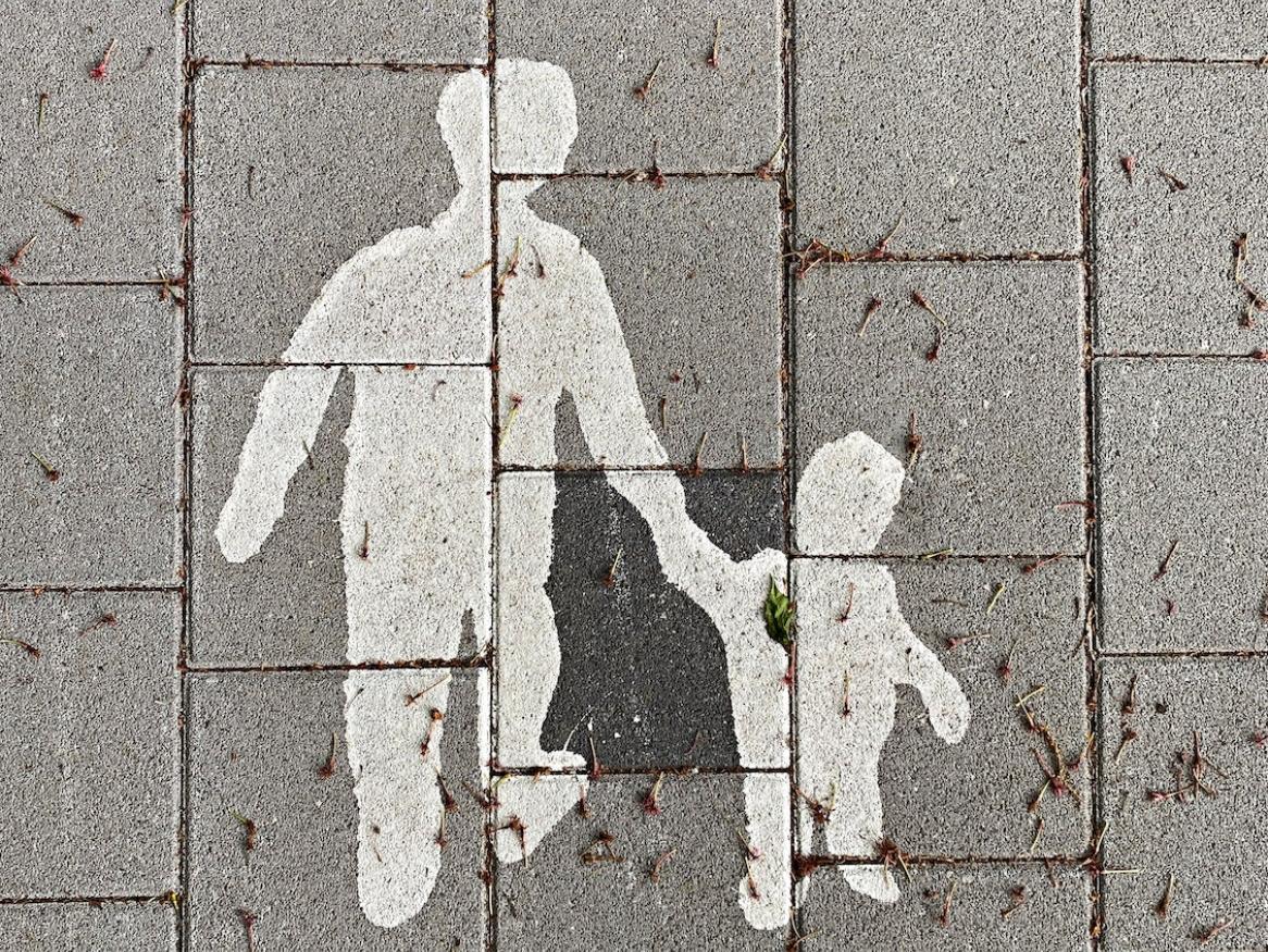 A drawing of a parent and child on the pavement.