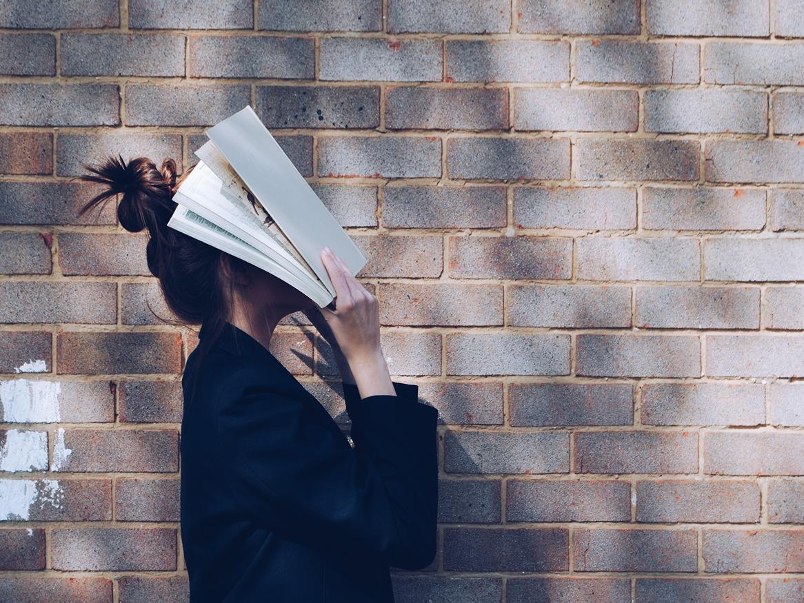 Girl with face in a book
